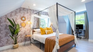 A modern bedroom with a four-poster bed, a large potted plant, and a desk with a chair. - Spacious Getaway 15 mins from Downtown Atlanta (Decatur)