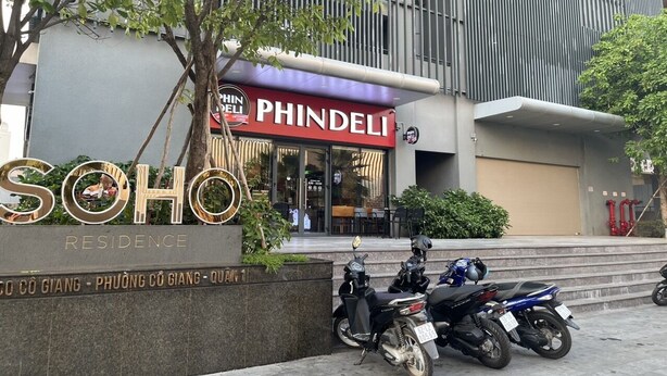 En byggnad med en skylt där det står ”PHINDELI” och ”SOHO RESIDENCE”, och med motorcyklar parkerade framför.