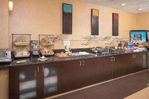 Een buffetopstelling met diverse gerechten en een 'Minute Maid' bord.