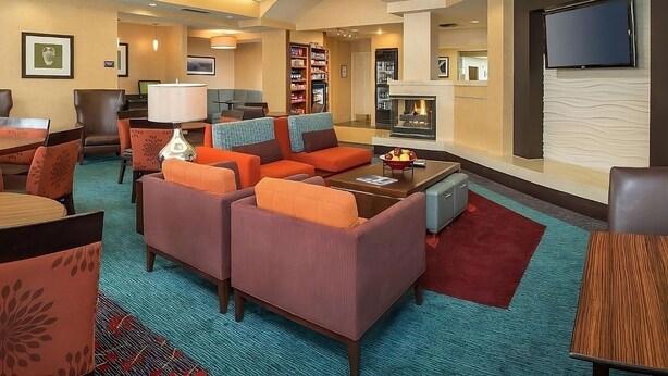 A hotel lobby with seating areas, a fireplace, a television, and a bookshelf. - Modern Convenience Meets Comfort in Charleston! Pool, Pets are Allowed Here (Charleston)