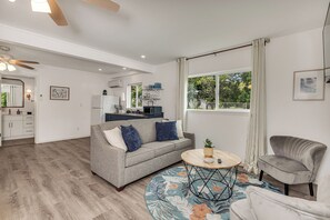 A modern living room with a grey sofa, a round coffee table, and a grey armchair. - Moana Sunrise Villa- Resort-like pool, hot tub and A/C! This place has it all! (Keaau)