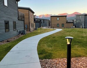 A residential area with modern houses, a curved pathway, and a mountain backdrop.