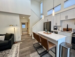 Enjoy cooking in this well-equipped kitchen with a refrigerator, stove, and wooden island.