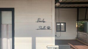 Une façade d'immeuble avec un mur recouvert de panneaux en bois, une fenêtre et une rambarde en métal.