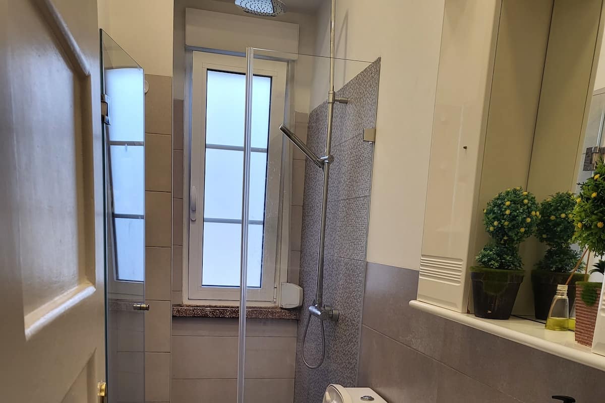 Un baño pequeño con inodoro, ducha y lavamanos.