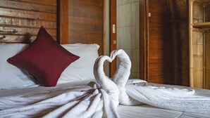 A bed with a red pillow and towels arranged in a heart shape. - KINTAMANI Paradise - 1BR (Kintamani)
