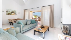 A modern living room with a sofa, coffee table, and dining area.
