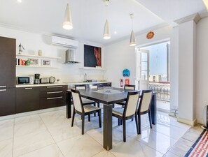 A modern kitchen with dark cabinetry, a central island, and pendant lighting.