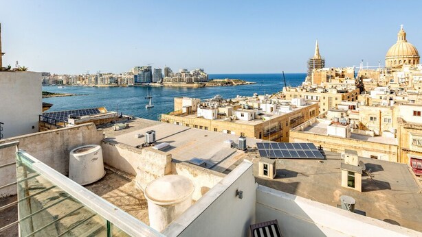 A rooftop with solar panels, a water tank, and a view of the city and sea. - Mesmerising Views for a 2BR APT in the Capital ! (Valletta)