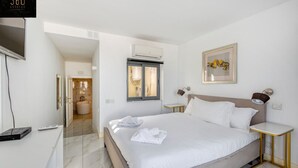 A modern hotel room with a large bed, a television, and a small table. - Mesmerising Views for a 2BR APT in the Capital ! (Valletta)