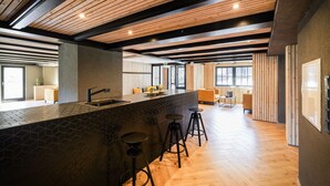 Une cuisine moderne dotée d’un grand îlot central, de tabourets de bar et offrant une vue sur l’espace de vie.