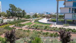 A modern building with a landscaped garden area, featuring a curved pathway and various plants.