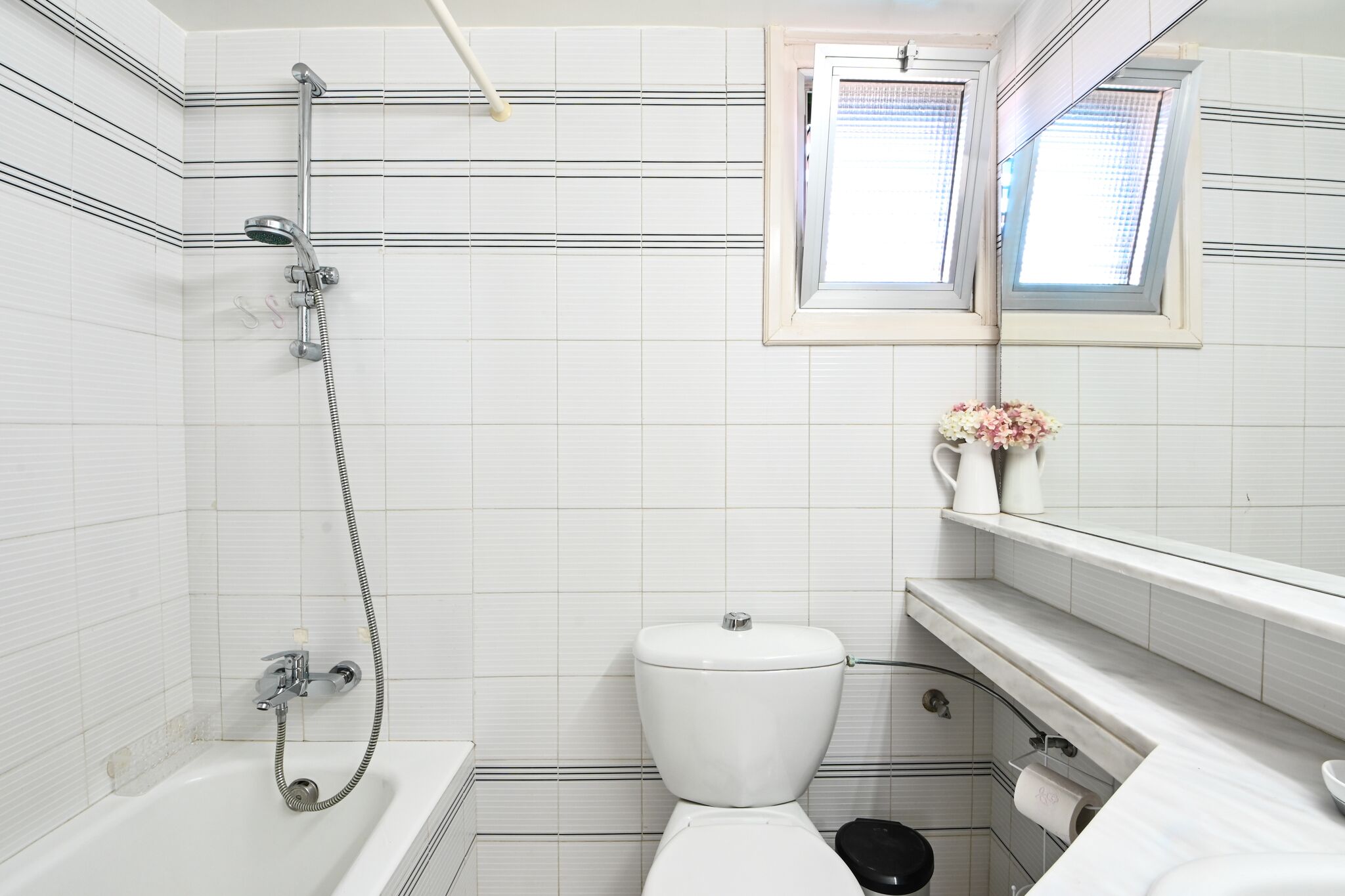 A bathroom with a bathtub, toilet, and a shower.