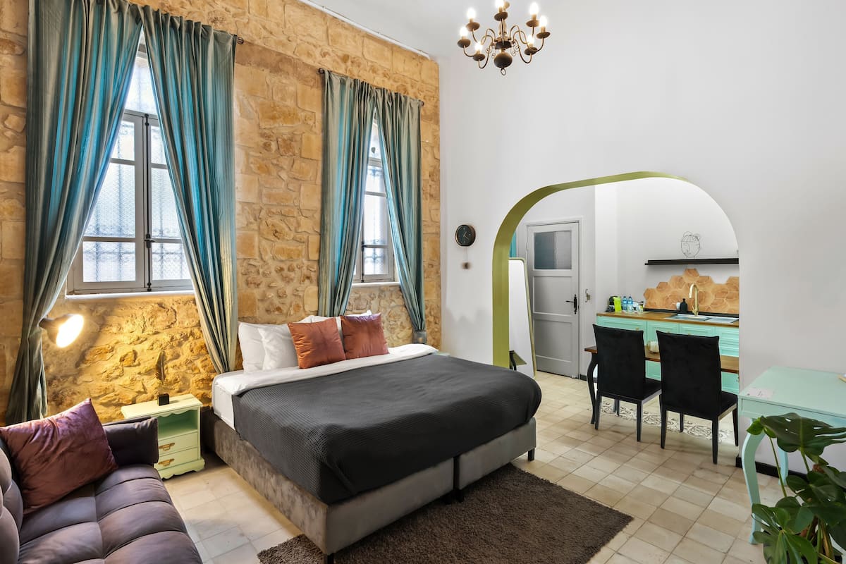Ein Schlafzimmer mit Stehwand, einem Bett, einem Schreibtisch und einem Stuhl.