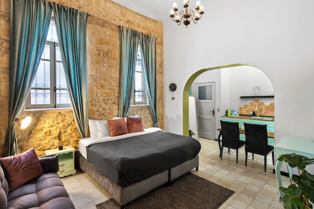 Ein Schlafzimmer mit Steinwand, einem Bett, einem Schreibtisch und einem Stuhl.