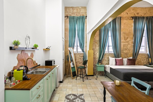 A compact room with a kitchenette, a bed, and a dining area. - Helios Boutique Suites by La Finca Hotel (Beersheba)