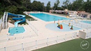 Ein Schwimmbecken mit einer blauen Rutsche und einem Wasserspielbereich.