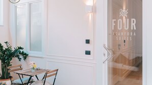 A hotel room with a wooden bench, a potted plant, and a wall-mounted light fixture. - Four - Acanfora Suites (Pompei)