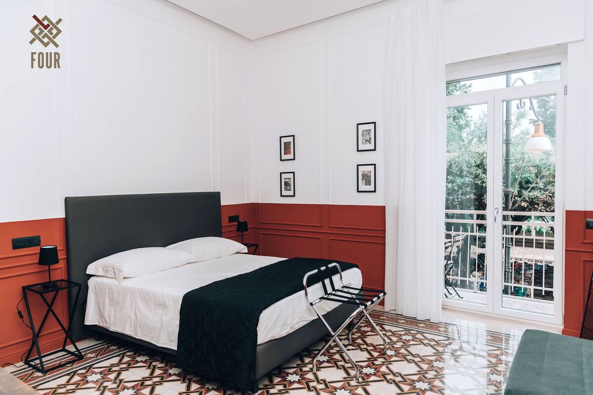 A bedroom with a bed, a window, and a door.