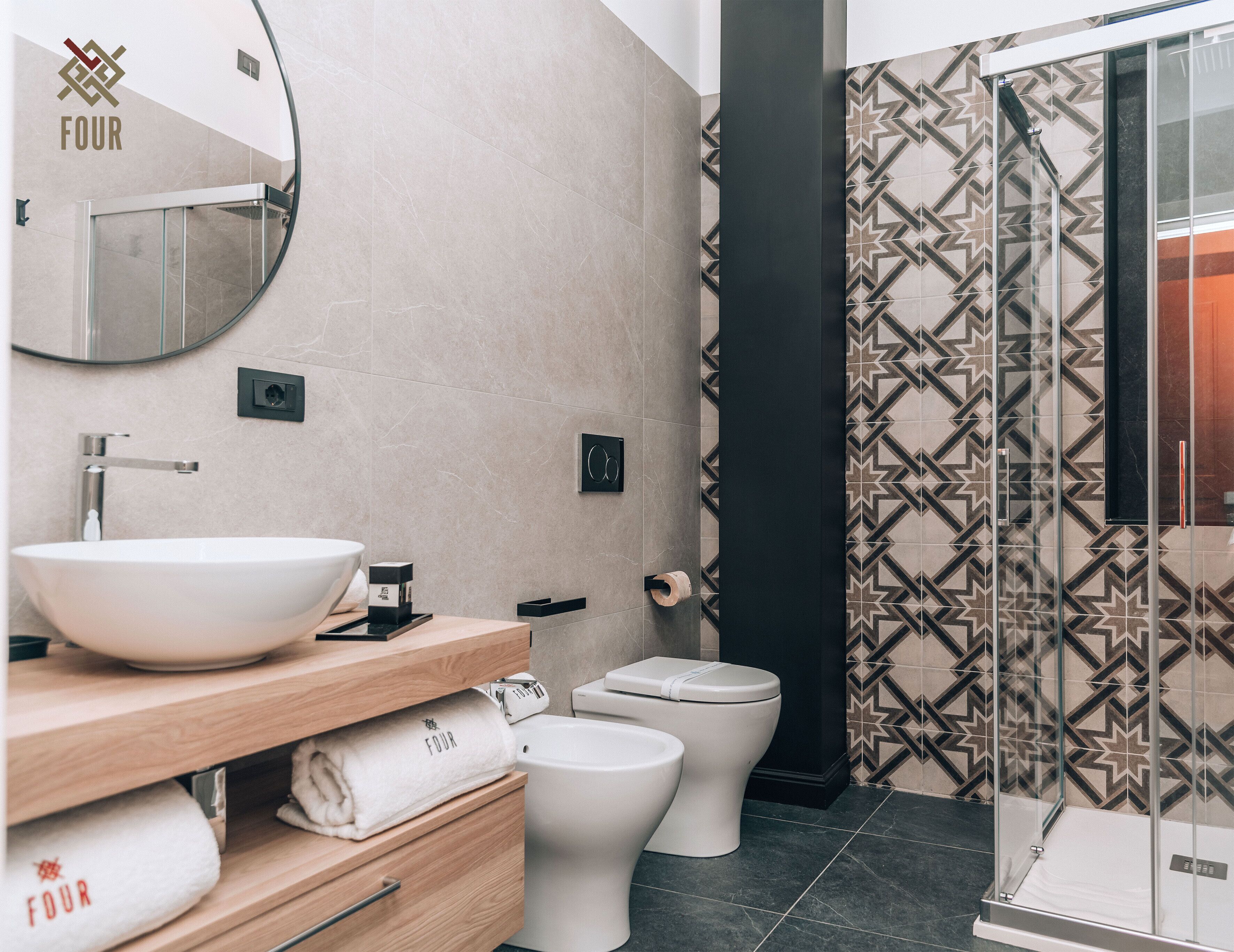 A modern bathroom with a large mirror, a vessel sink, a toilet, and a shower area.