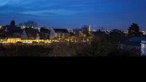 A nighttime view of a residential area with houses and a distant tower. - Chic and modern apartment (Châtillon)
