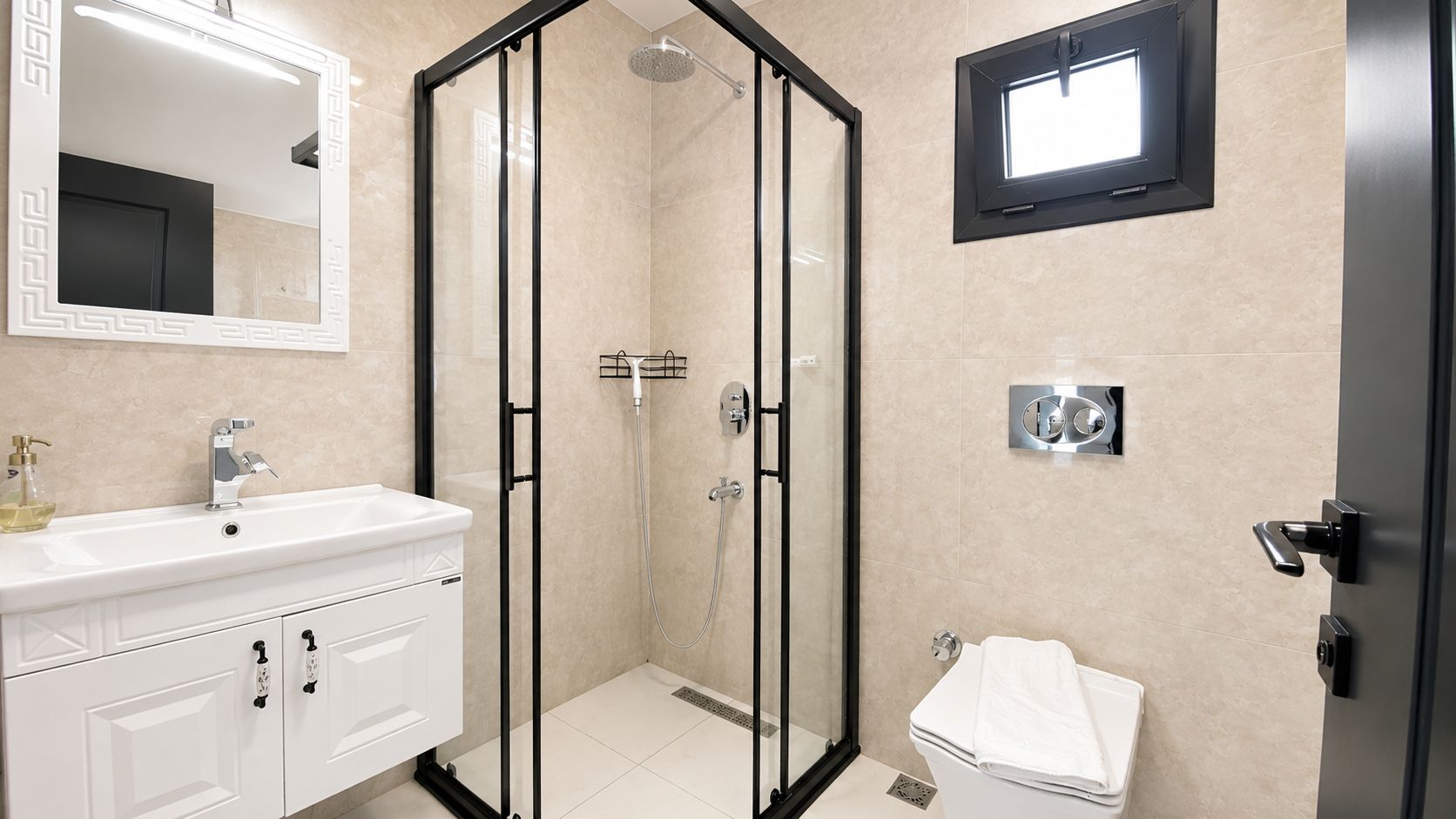 Ein modernes Badezimmer mit einer Duschkabine, einem weißen Waschbecken mit Armatur und einer Toilette.