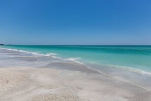 A beach with clear turquoise water and a sandy shore.