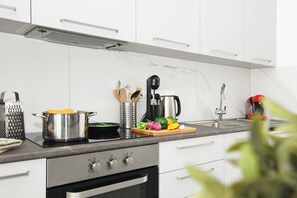 Enjoy cooking with a fully equipped kitchen featuring a stainless steel stove, cabinetry, and a coffee maker.