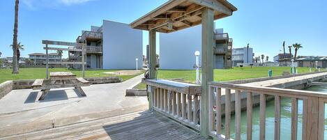 A wooden deck with a viewing platform, a pool, and modern buildings in the background.