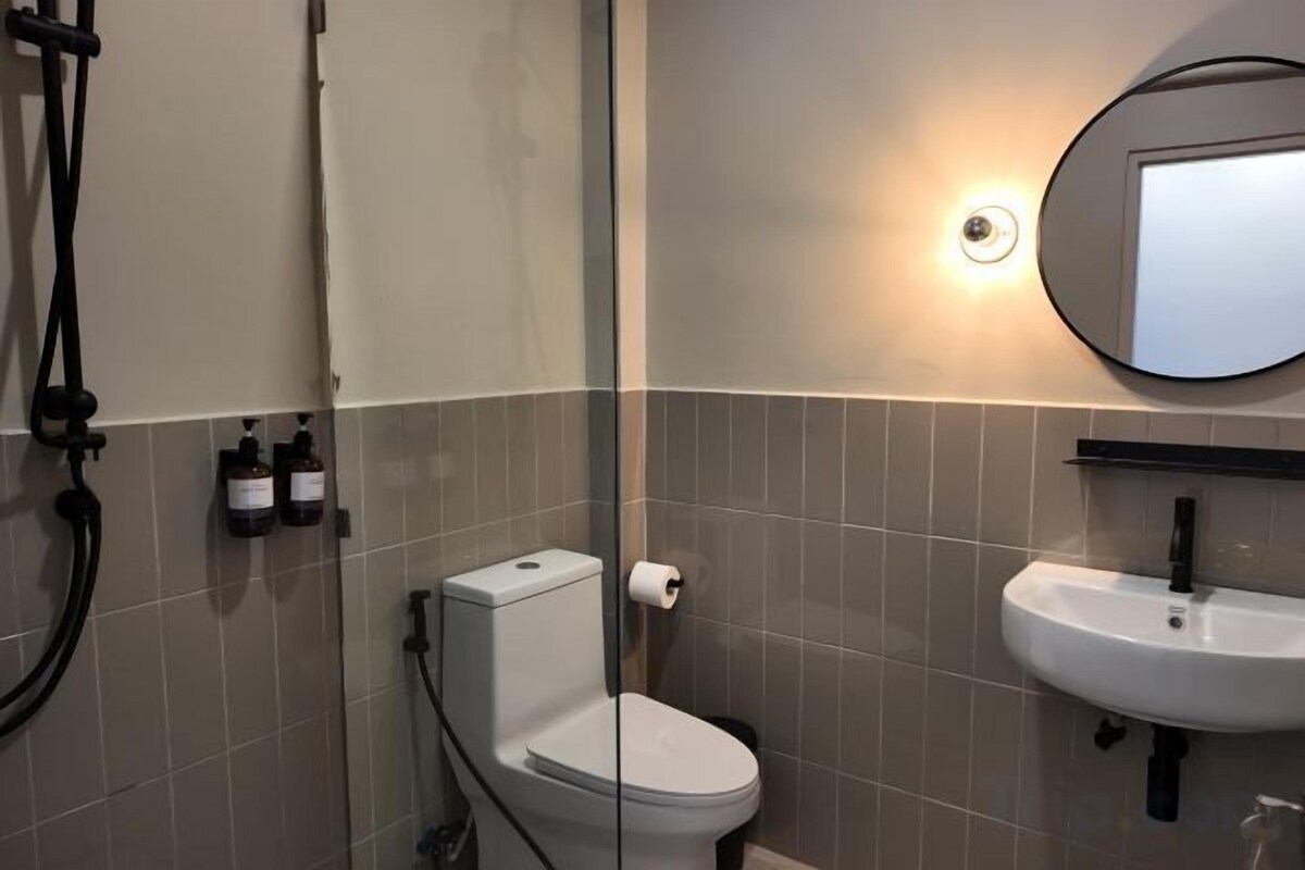 A bathroom with a toilet, sink, and a shower.