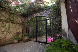A gated entrance with a sign reading "Riad Semlalia," surrounded by lush greenery and potted plants. - Riad Semlalia (Fes)