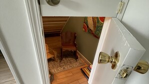 A room with a wooden floor, a small wooden chair, and a colorful painting on the wall. - Spacious cottage by lake & walking trails, 1 mile from downtown Shipshe. (Shipshewana)