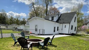 A white building with a sloped roof and a small porch area. - Spacious cottage by lake & walking trails, 1 mile from downtown Shipshe. (Shipshewana)