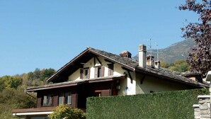 Un chalet traditionnel doté d’un toit à pente, de poutres en bois et d’une cheminée.