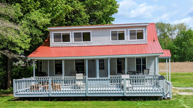 A two-story house with a red roof and a covered porch. - Waterfront house on the upper most portion of the West Branch Delaware. (Deposit)