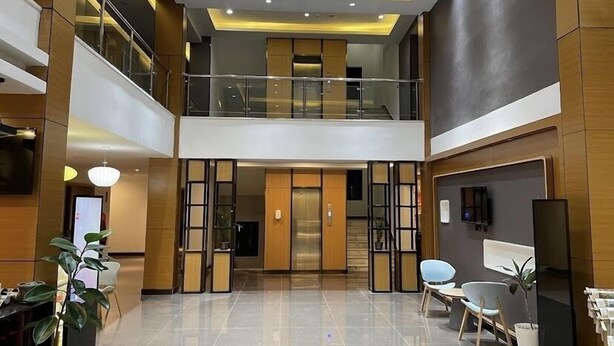 A modern hotel lobby with a spacious layout, a second-floor balcony, and a reception desk. - Ivy Hotel Addis Ababa (Addis Ababa)