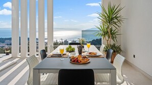 A balcony table with breakfast items, a view of the sea, and a potted plant. - Villa Sagnia, 4 en-suite bedrooms, sea views (Makarska)