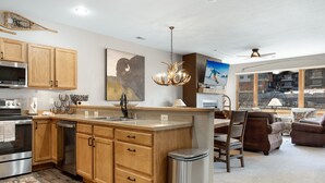 A modern kitchen with wooden cabinets, stainless steel appliances, and a central island.