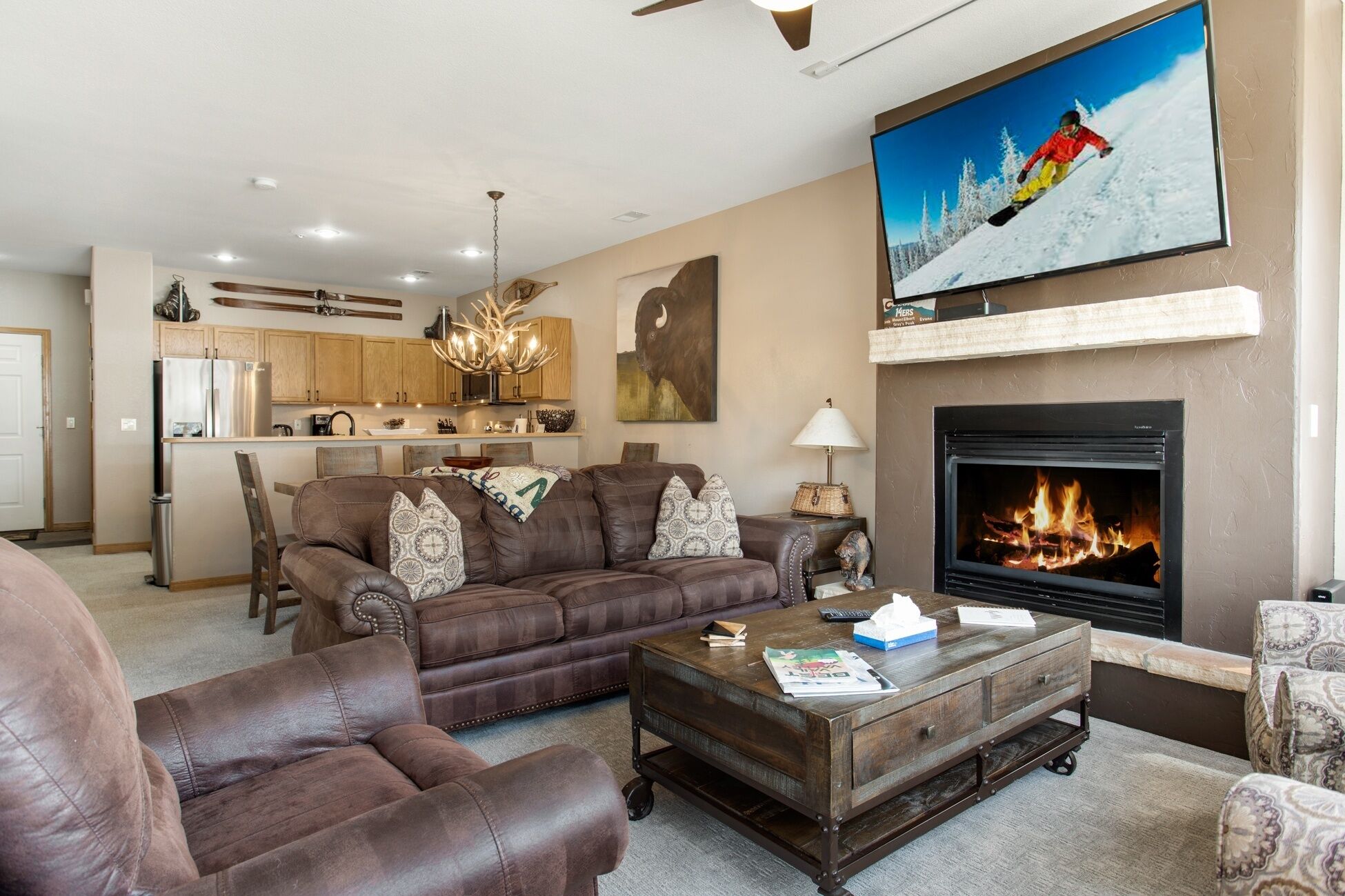 A living room with a fireplace, a sofa, a coffee table, and a television mounted on the wall.