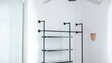A bedroom with a bunk bed, a black metal shelf unit, a unique ceiling fan, and a wooden accent wall.