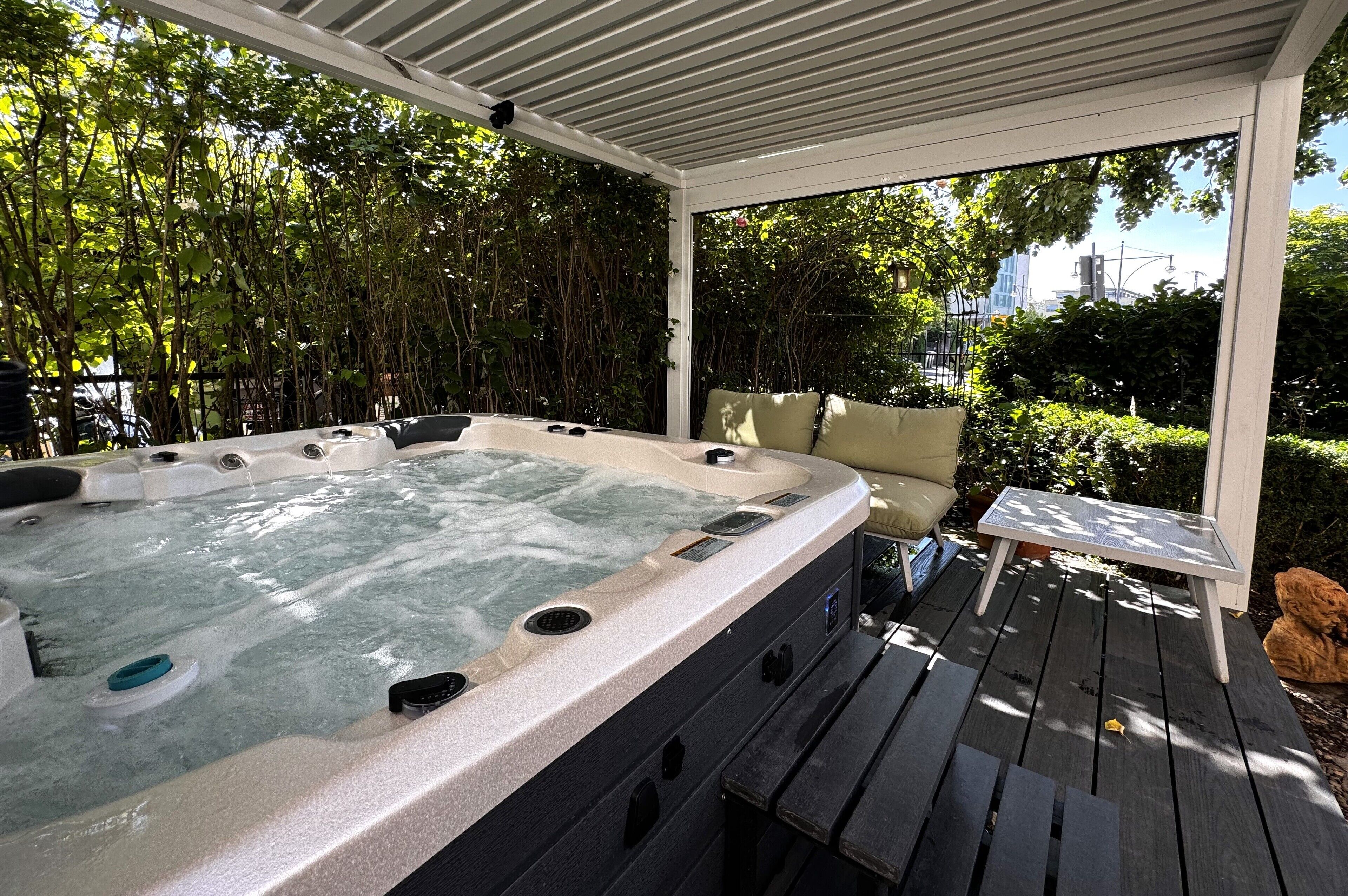 Un jacuzzi bajo un porche cubierto con vistas a la ciudad.