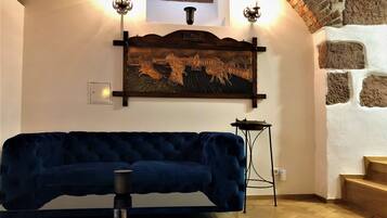 A room with a dark blue sofa, a decorative wall piece, and a small table.