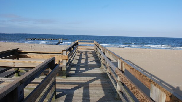 A wooden boardwalk leading to a sandy beach with the ocean in the background. - Historic Beach Side Getaway - Pet Friendly, Wifi 3 Bedroom Cottage by RedAwning (Norfolk)