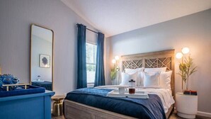 Ein Schlafzimmer mit Bett, Nachttisch und einem großen Spiegel.