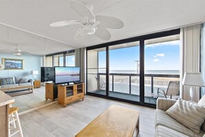 Relax in this ocean-view living area with a flat-screen TV, comfortable sofa, and balcony seating.