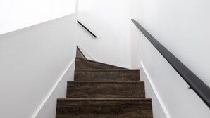 A staircase with dark wooden steps and white walls.