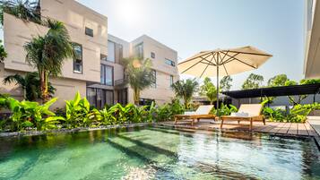 Een buitenzwembad en ligstoelen