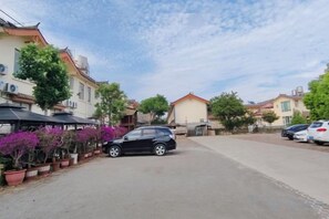 A residential street with parked cars, potted plants, and houses. - Tiandi Renhe Inn (Shilin)