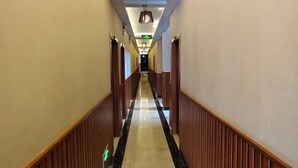 A long, narrow hotel corridor with wooden paneling on the walls and a shiny, reflective floor. - Tiandi Renhe Inn (Shilin)