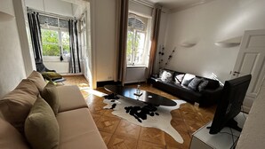 Una sala de estar con sofá, mesa de centro, televisor y chimenea.